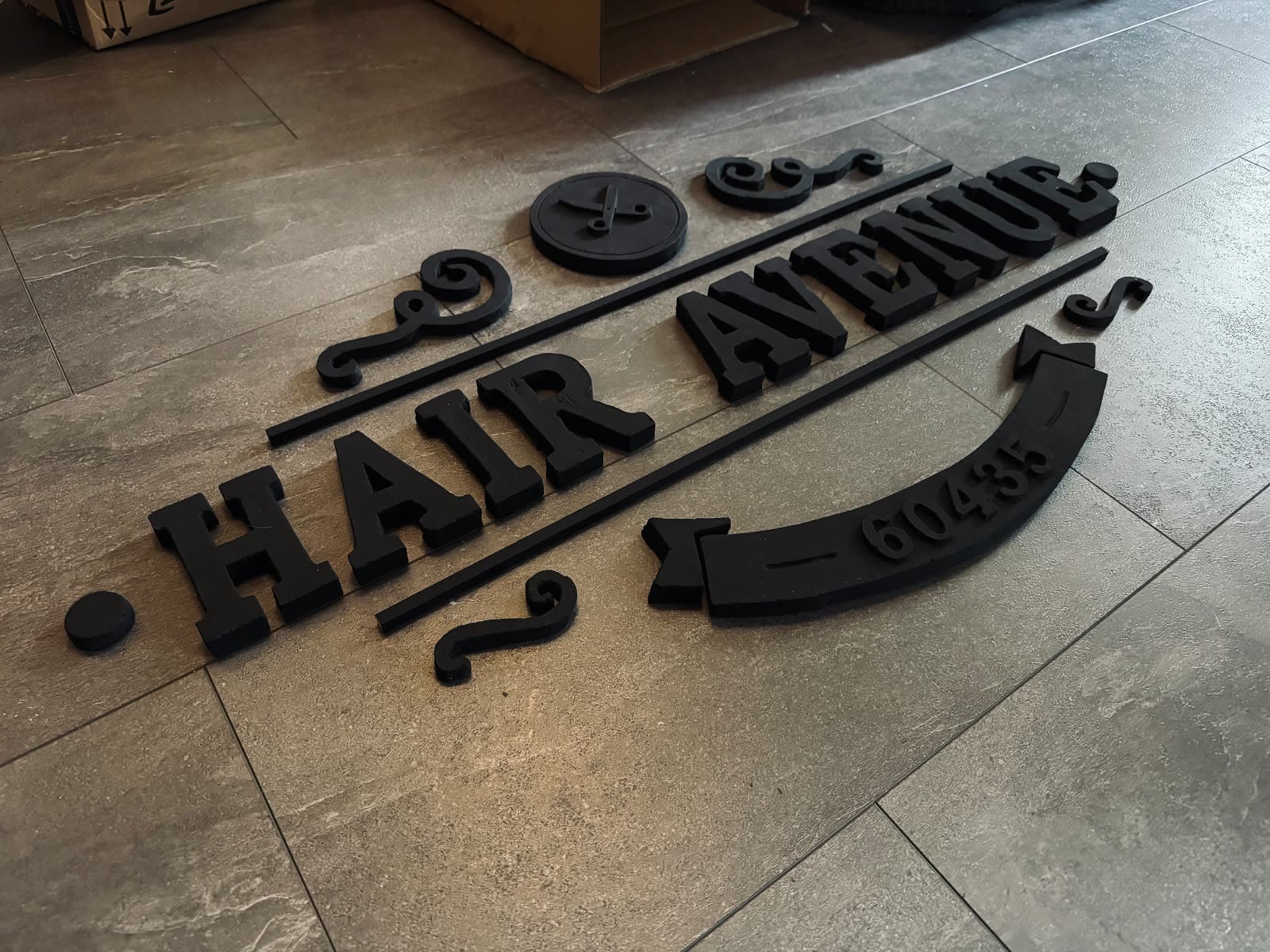 Alle Einzelteile des Schriftzugs vor der Montage auf dem Boden ausgelegt