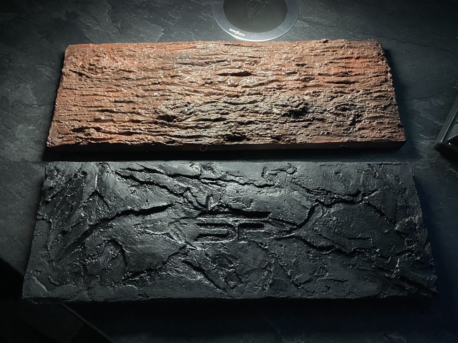 Handgefertigte Materialproben in Holz- und Steinoptik übereinander