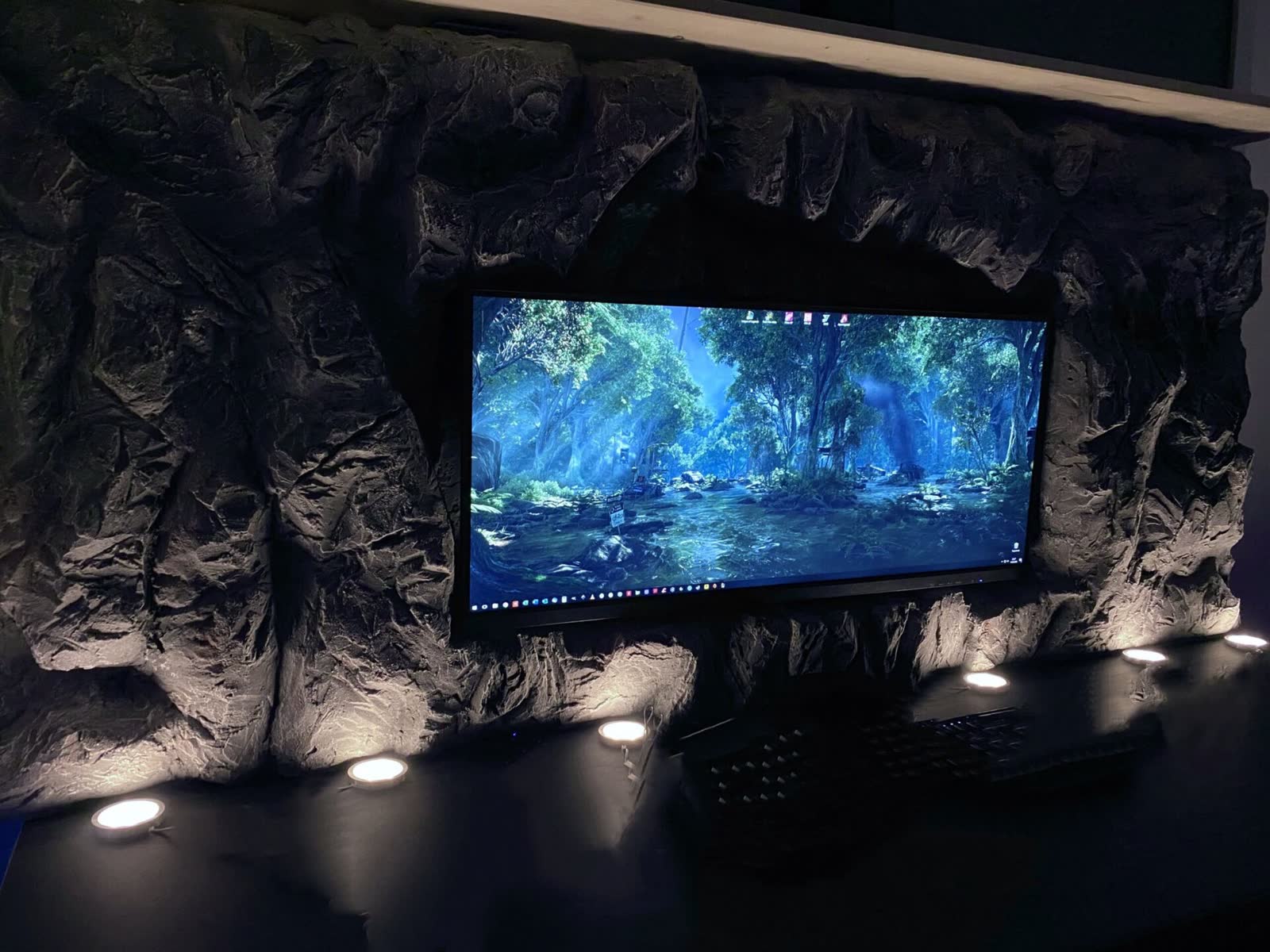 Kunststein-Felswand als Einfassung eines Monitors mit warmen LED-Spots