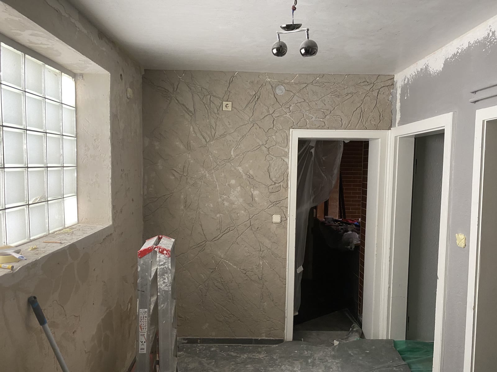 Modellierte Felsstruktur an der Wand eines Gastraums vor dem Farbauftrag