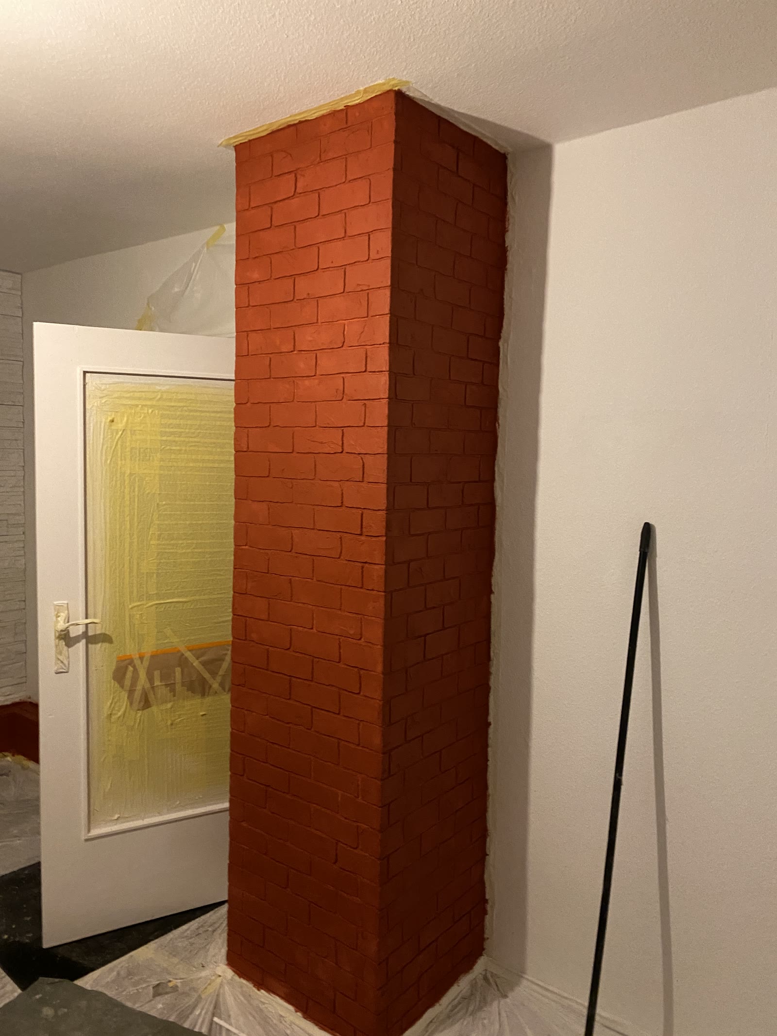 Säule mit modelliertem Ziegelrelief nach dem ersten Farbauftrag in kräftigem Rotorange