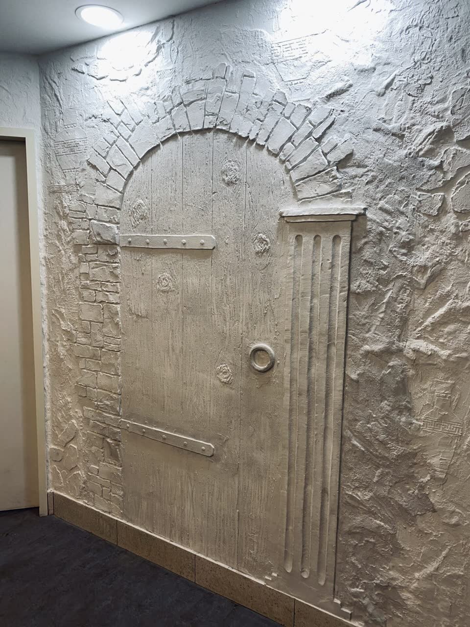 Kunststein-Türnische mit griechisch inspirierter Putzstruktur im Sanitärbereich