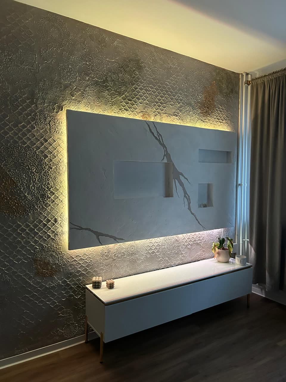 Beleuchtete TV-Akzentwand mit Goldader-Muster und Mandala-Relief in Kunststein