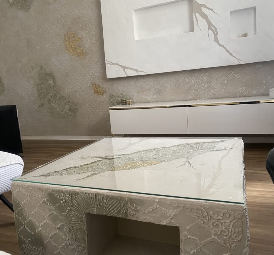 Wohnzimmer mit vorgesetzter Kunststein-TV-Wand und passendem Couchtisch